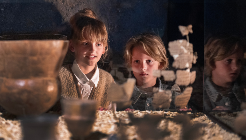 Twee kinderen bekijken object in vitrine Drents Museum