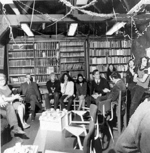 Groep mensen op stoelen voor een boekenkast