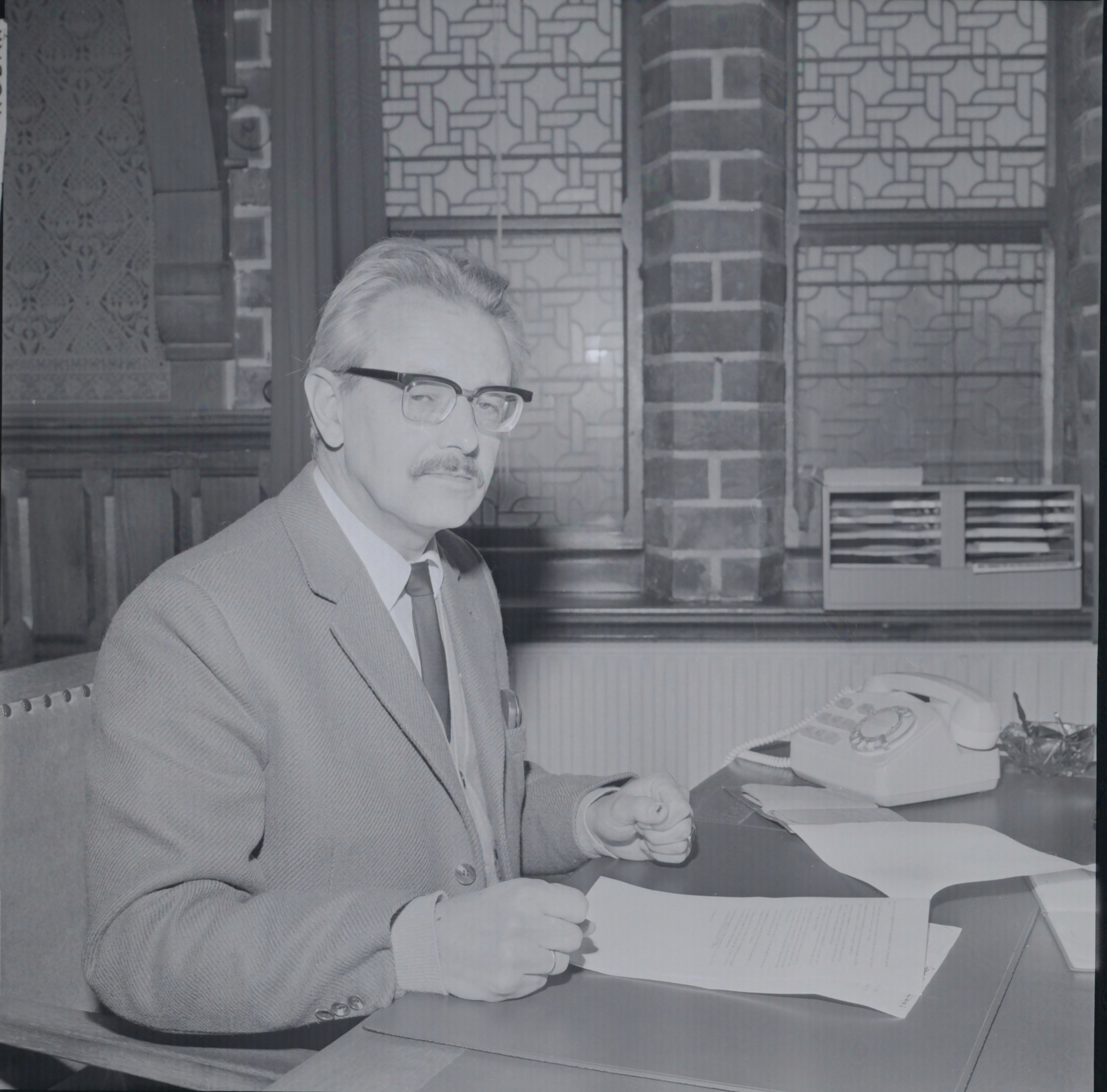 Man zit aan bureau met papieren