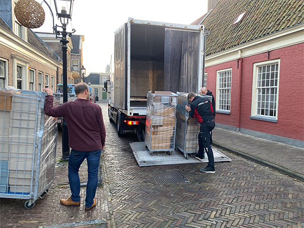 rolcontainers met archiefstukken van de rechtbank worden in een vrachtauto geladen