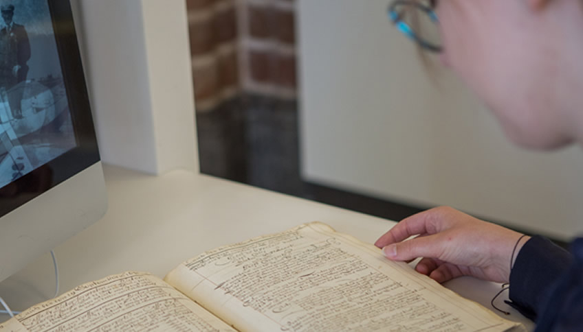 Bezoeker bekijkt archiefstuk