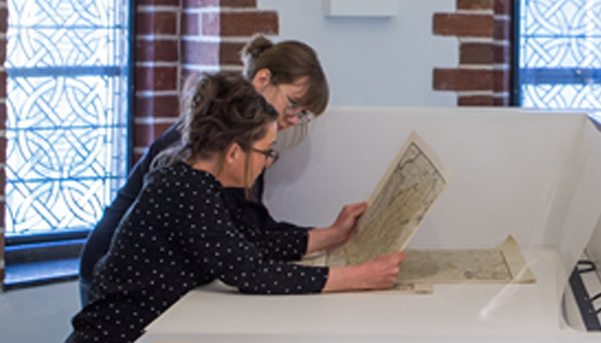 Twee vrouwen bekijken archiefstuk